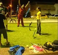 Treino de malabares à noite num gramado de praça